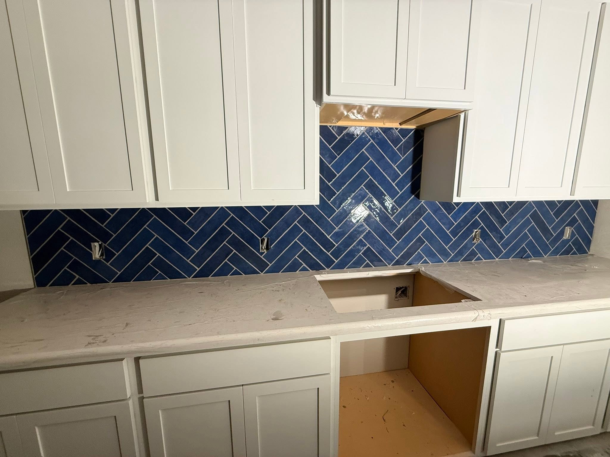 Kitchen backsplash with blue herringbone tile