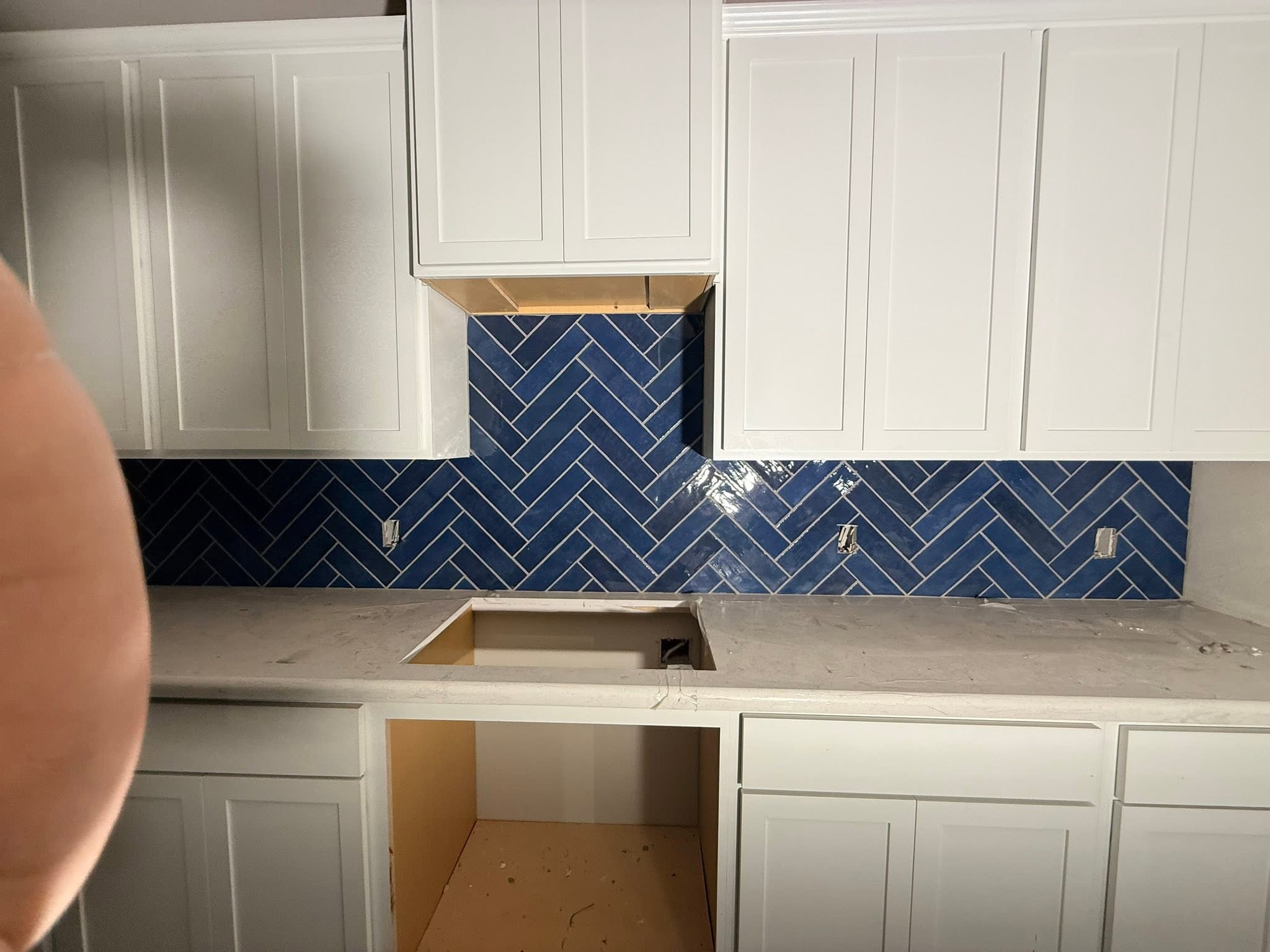 Kitchen backsplash with blue herringbone tile