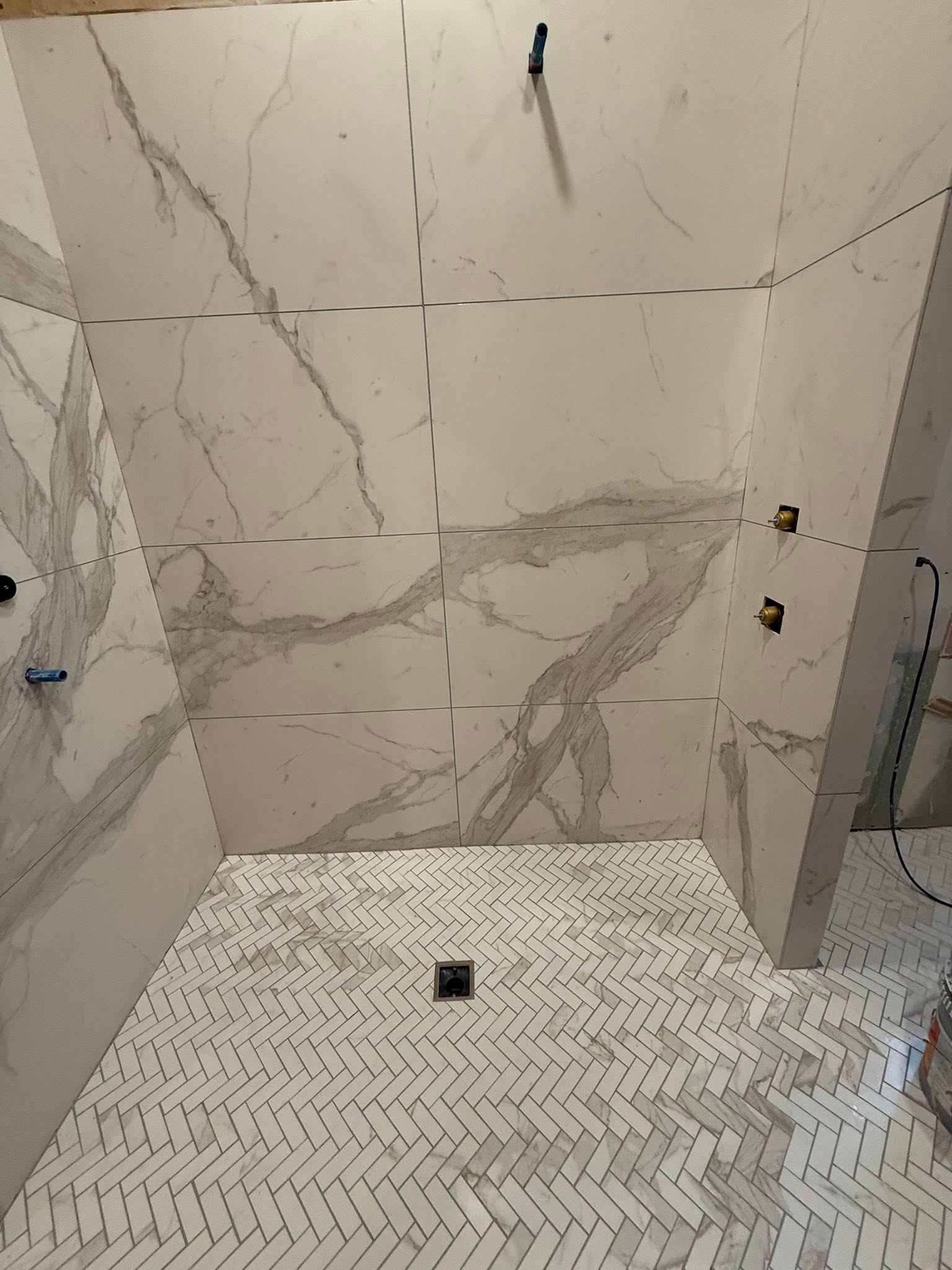 Shower remodel with marble herringbone tile